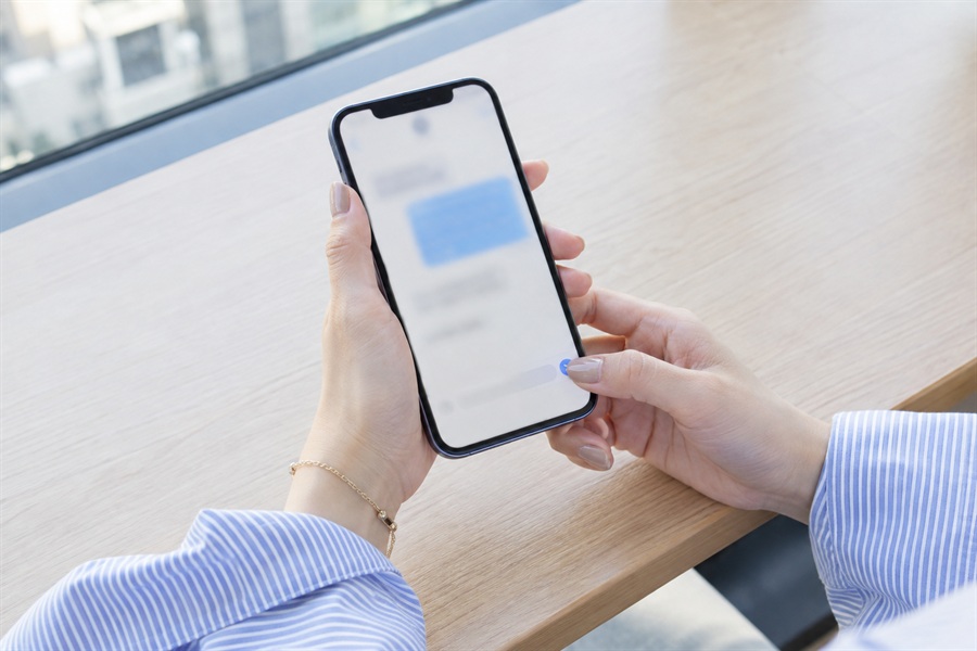 上司に話した日のうちに、退職希望日をスマートフォンのメッセージで送る女性の手元